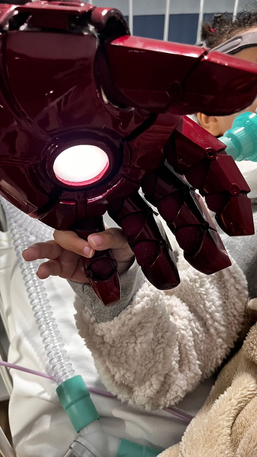 Criança segurando a mão iluminada do Coração de Aço